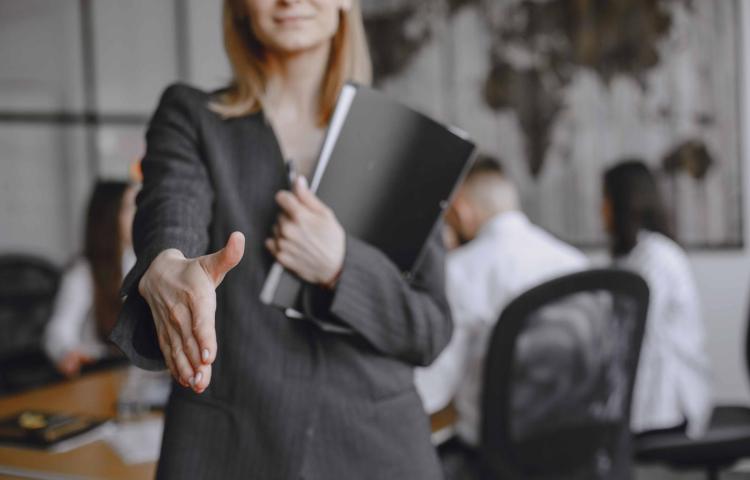 Kobieta wysciąga dłoń jak do powitania. Grafika ozdobna